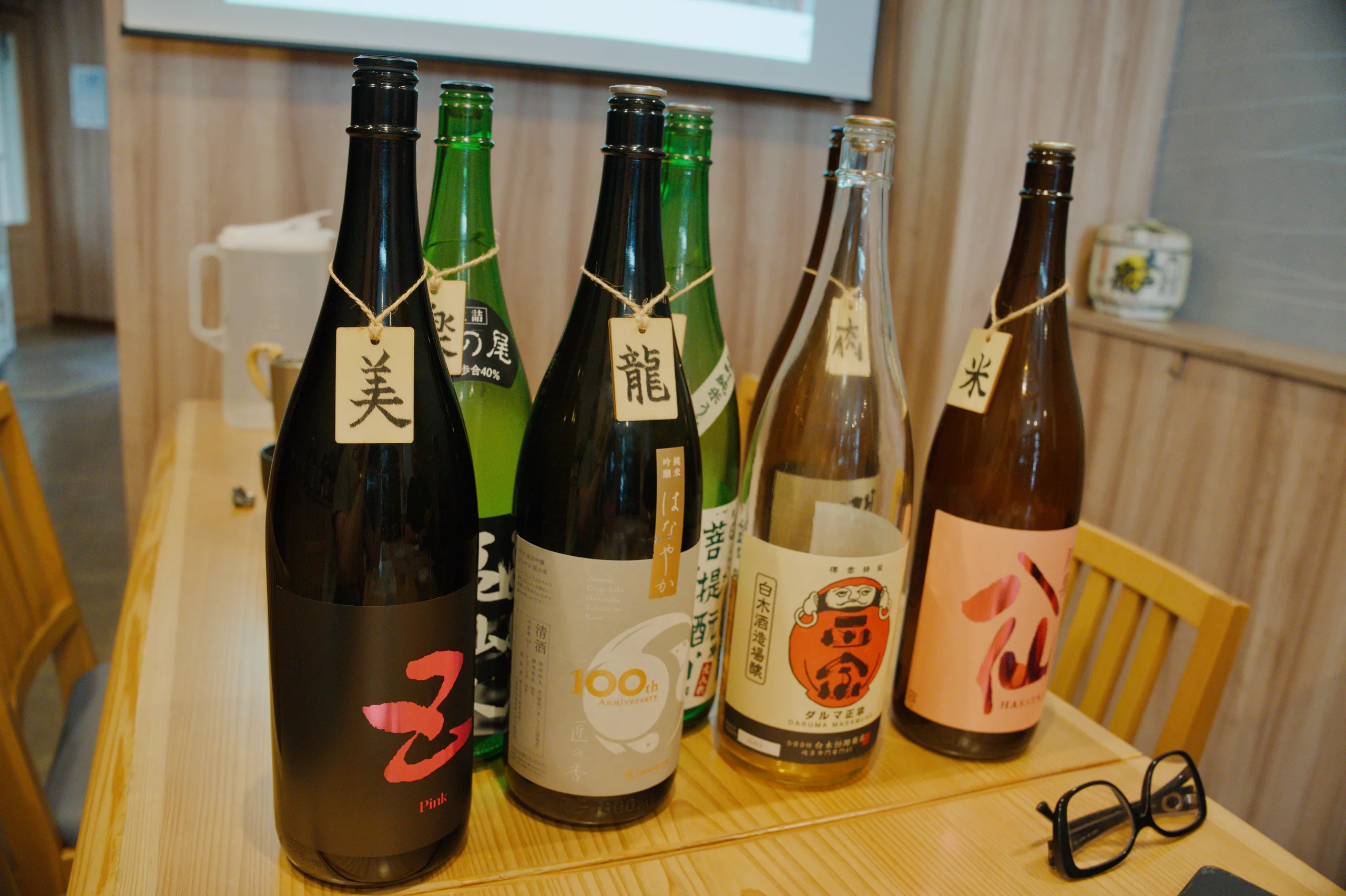 Several Japanese beer bottles with distinctive labels arranged on a wooden surface.
