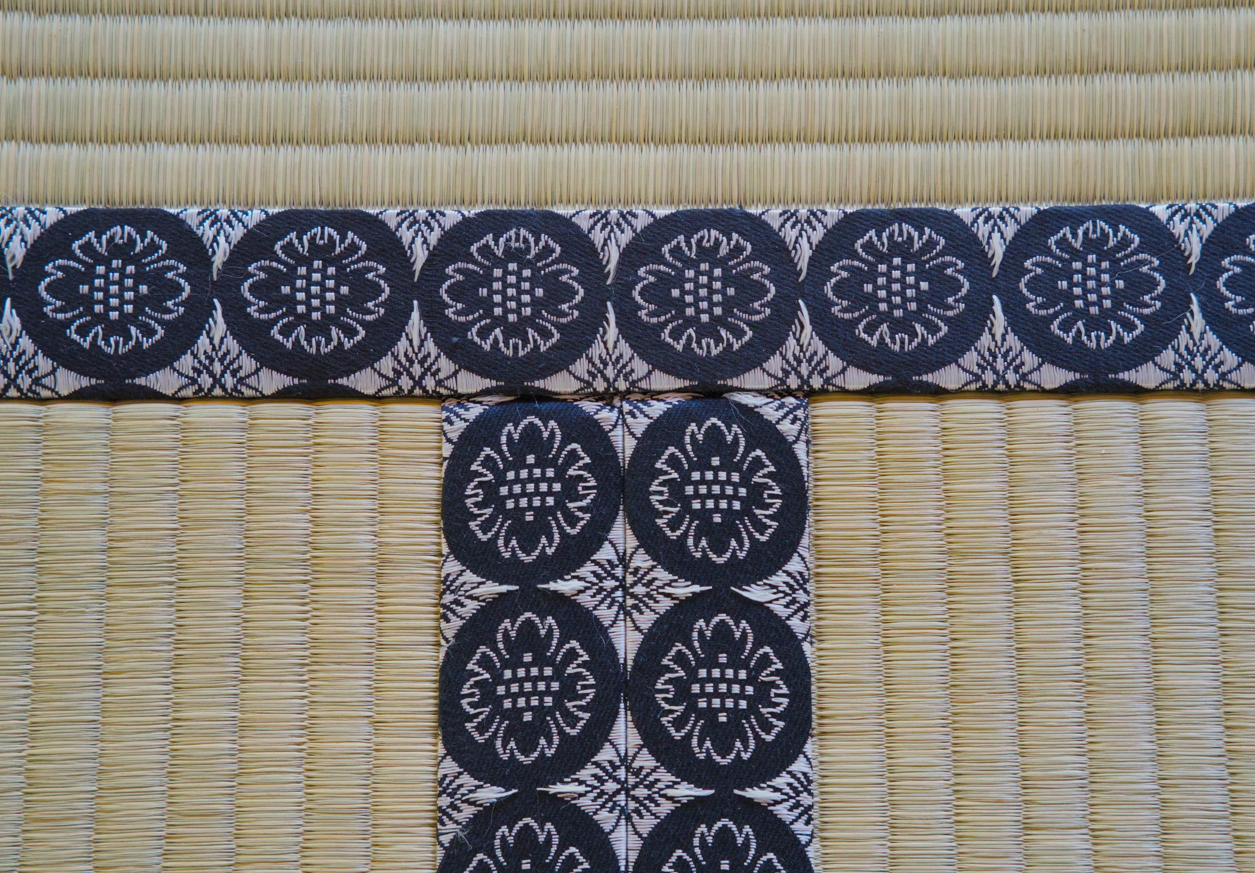 Blue and white patterned textile arranged in an L-shape over woven tatami matting.