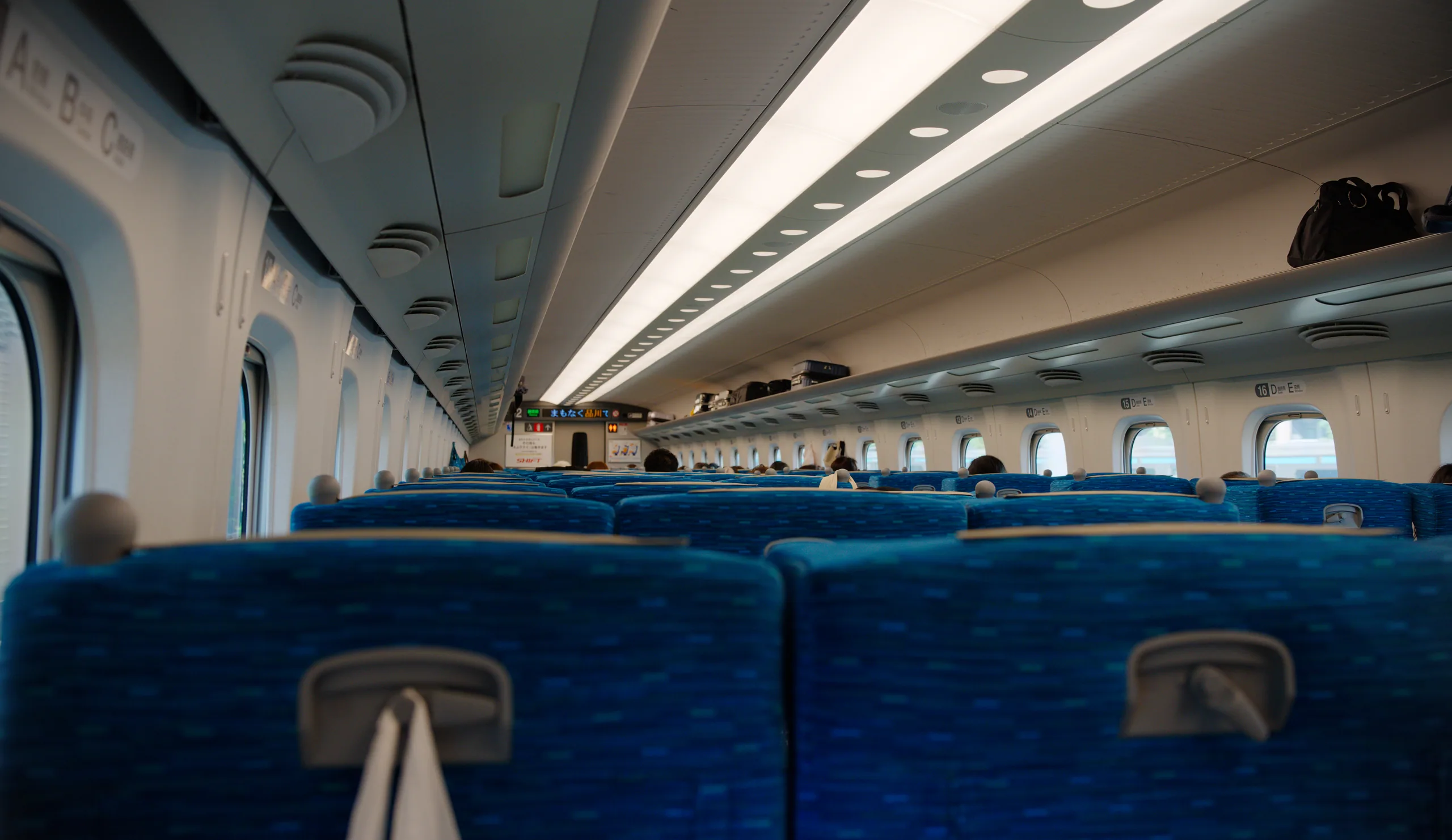 Blue-upholstered seats in a shinkansen cabin.