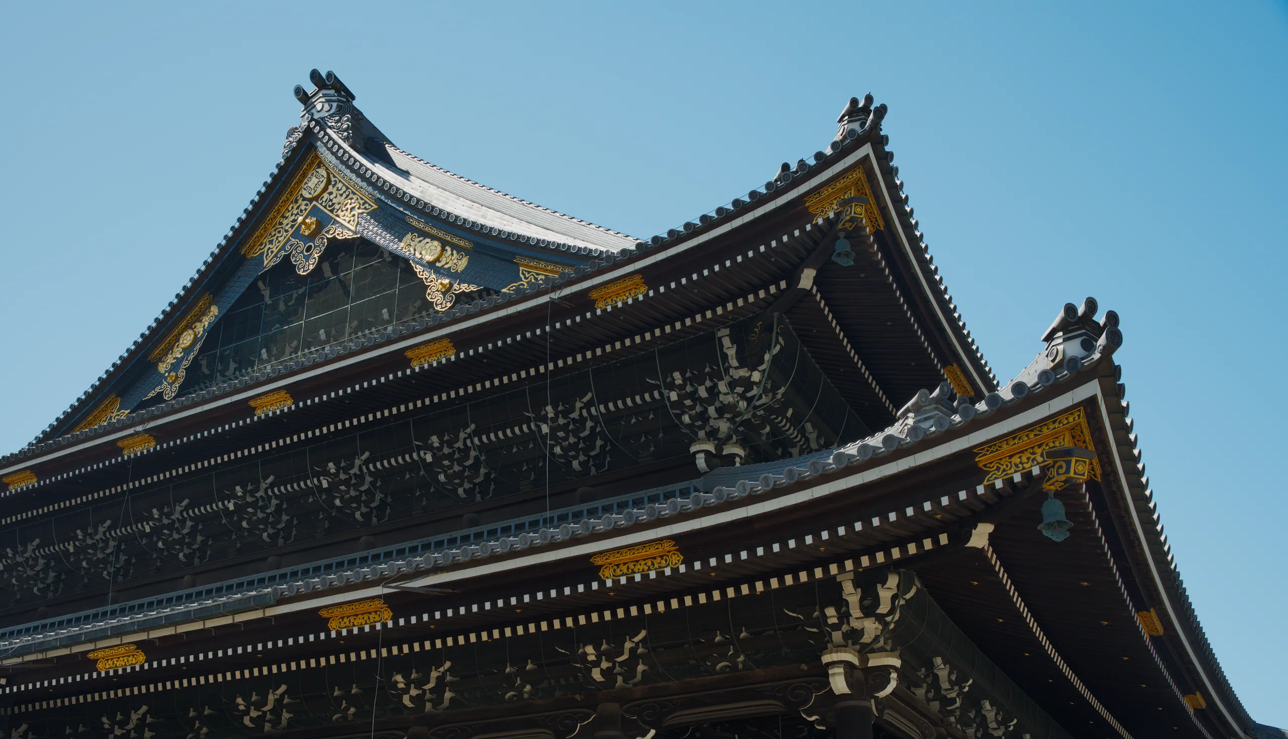 Temple roof edge with ornamental gold-trimmed details and curved upturned eaves.