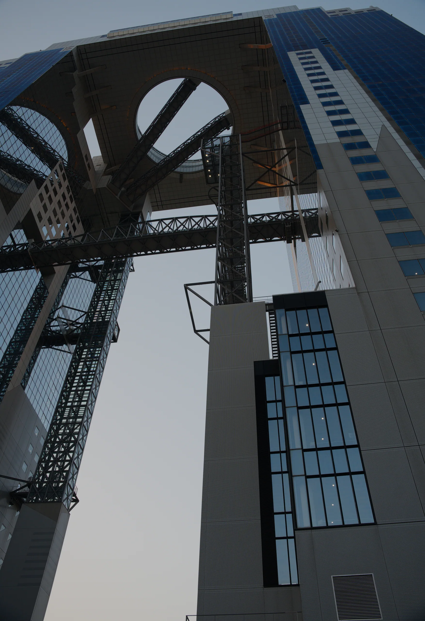 Industrial crane photographed from below, its metal framework and solar panels silhouetted against sky.