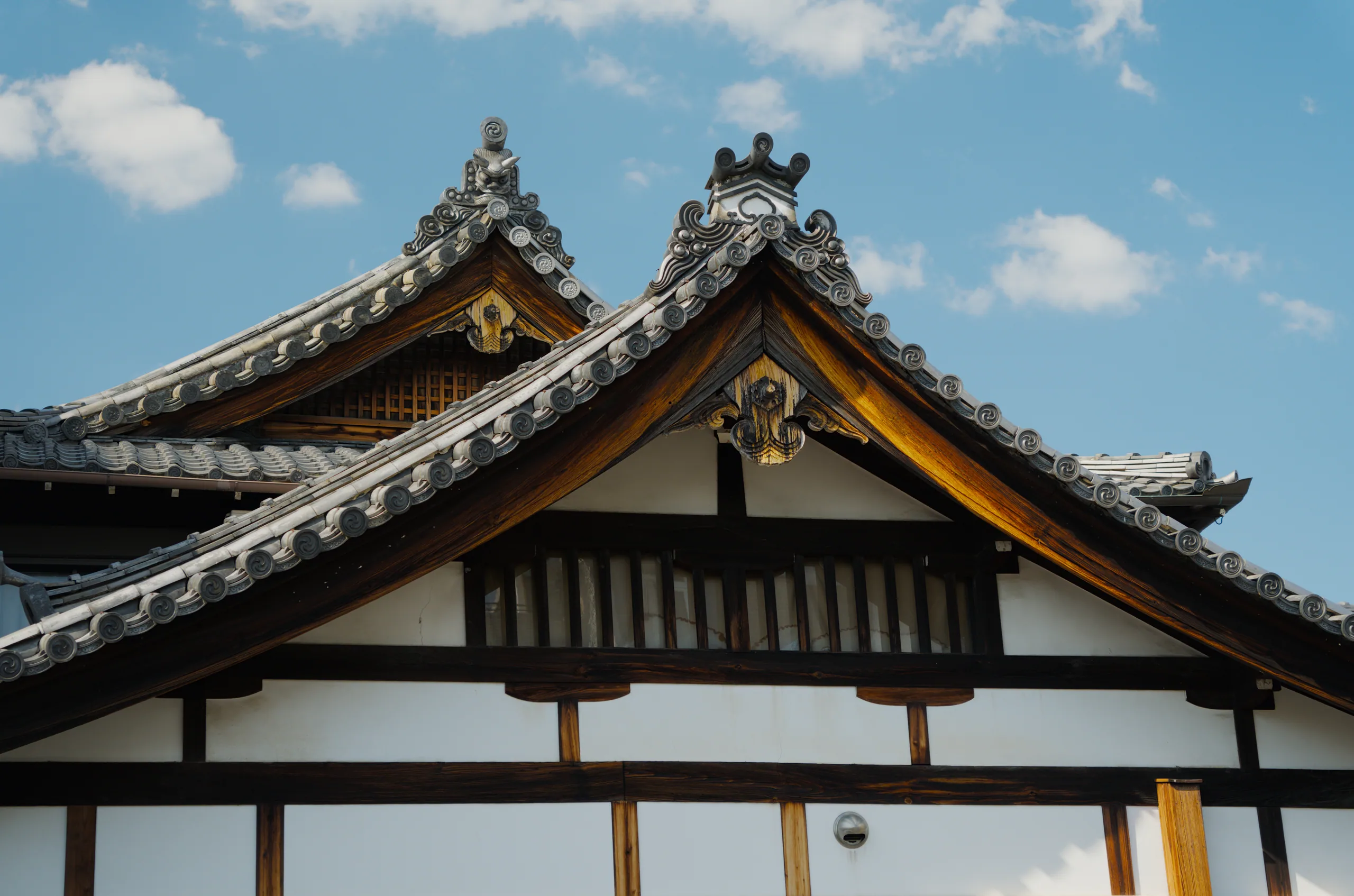 A Japanese temple with upturned roof edges and gold trim against blue sky.