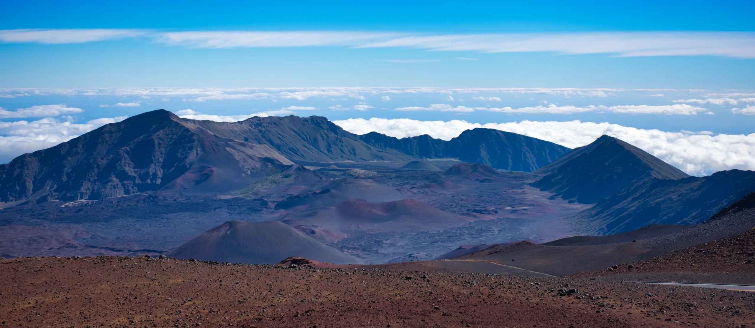 The floor of Haleakalā crater, cinder cones and lava flows spread out below the rim.