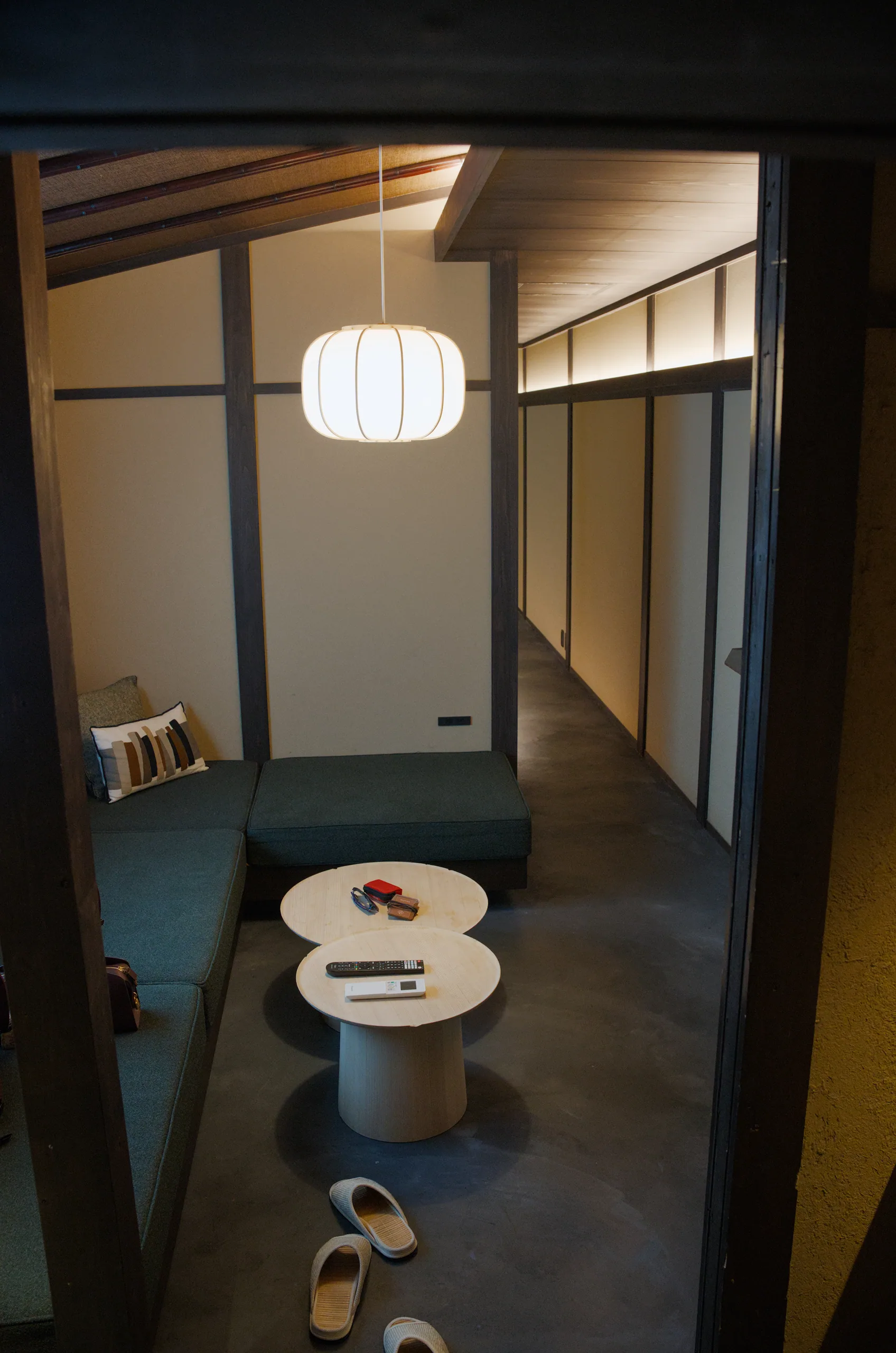 A minimalist Japanese room with a round side table and white paper lantern.