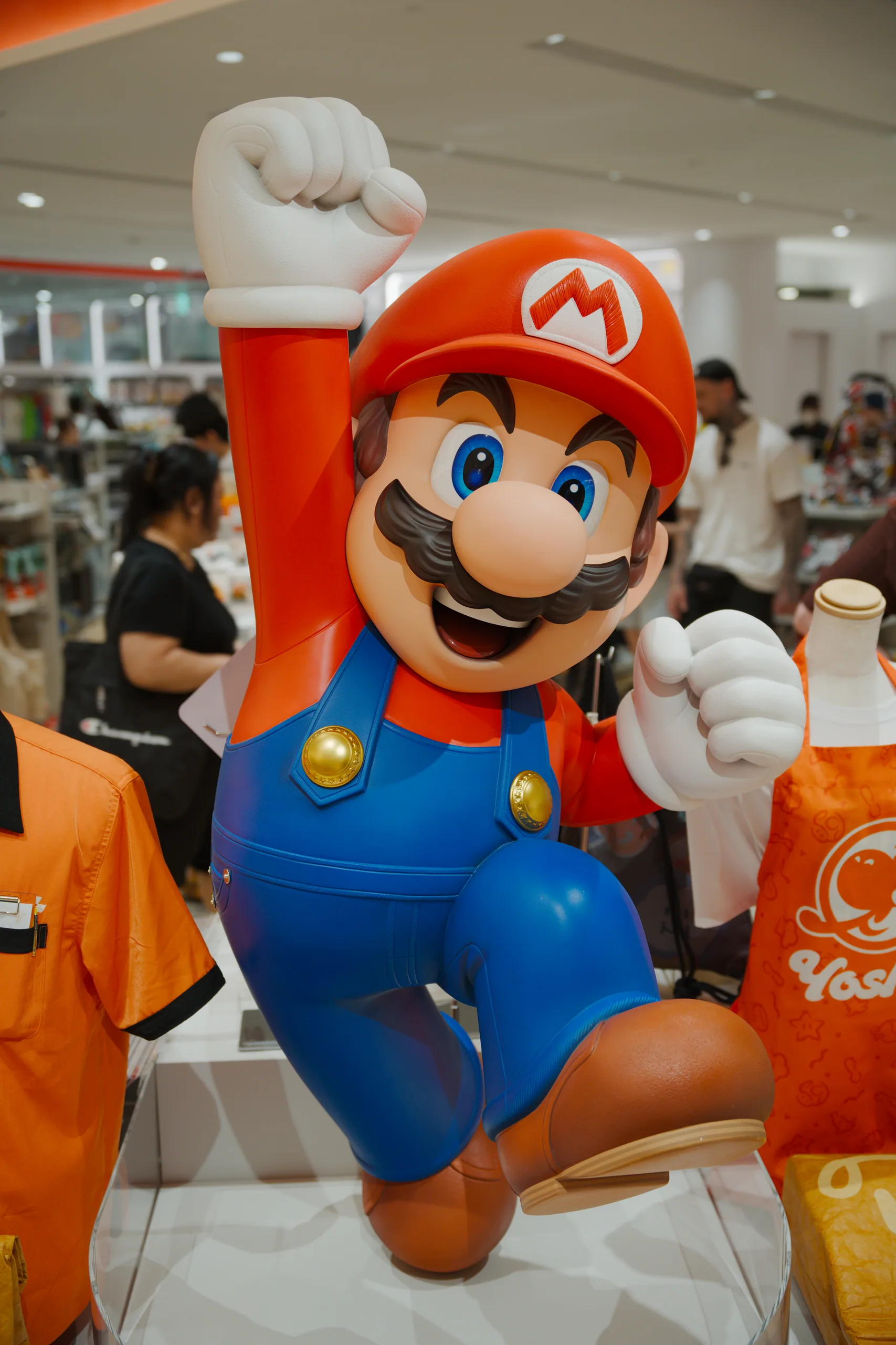Mario character figurine with red cap and blue overalls on display in an indoor retail space.