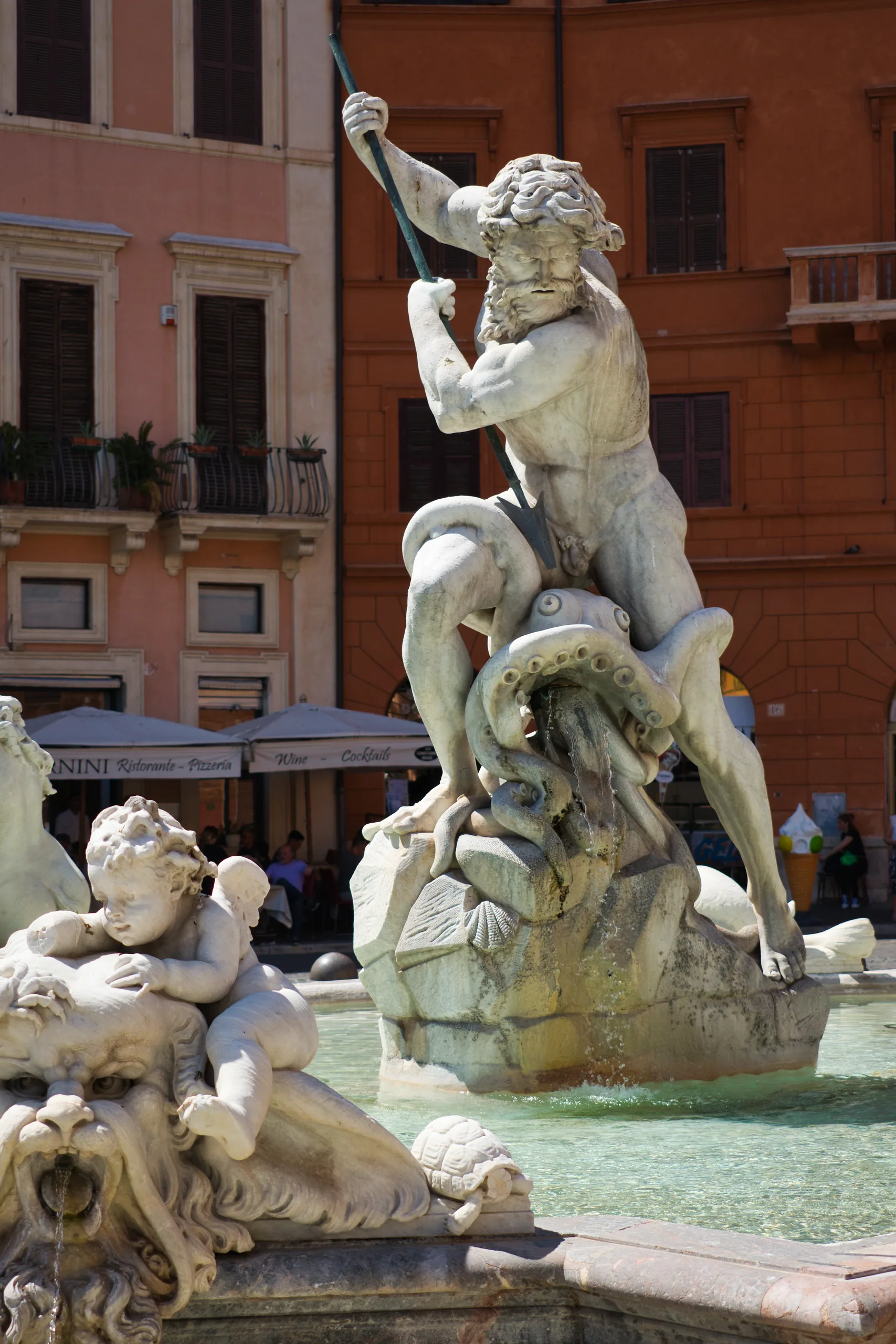 The Fountain of Neptune in Piazza Navona, the god raising his trident over a sea creature, cherubs and a lion mask on the basin below.