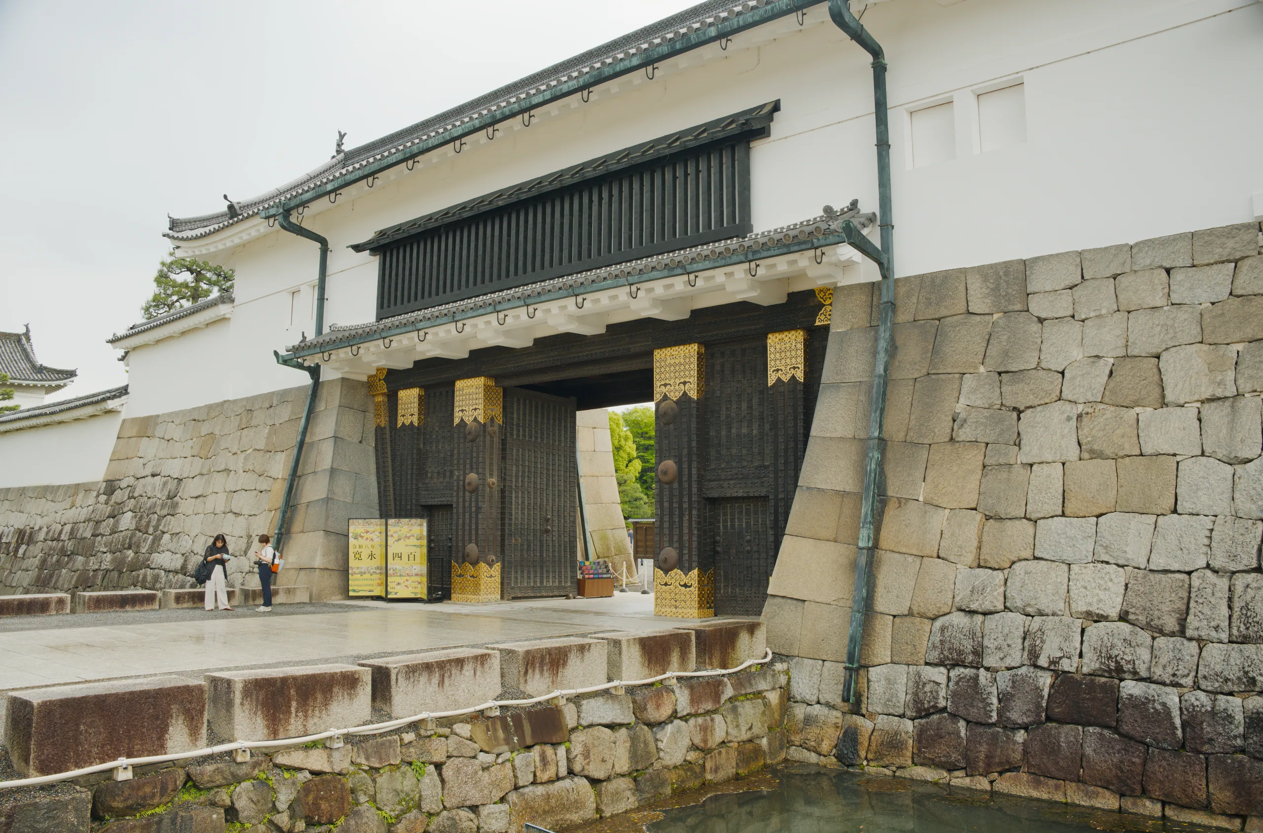 Castle gate with stone fortification walls and wooden entrance doors.