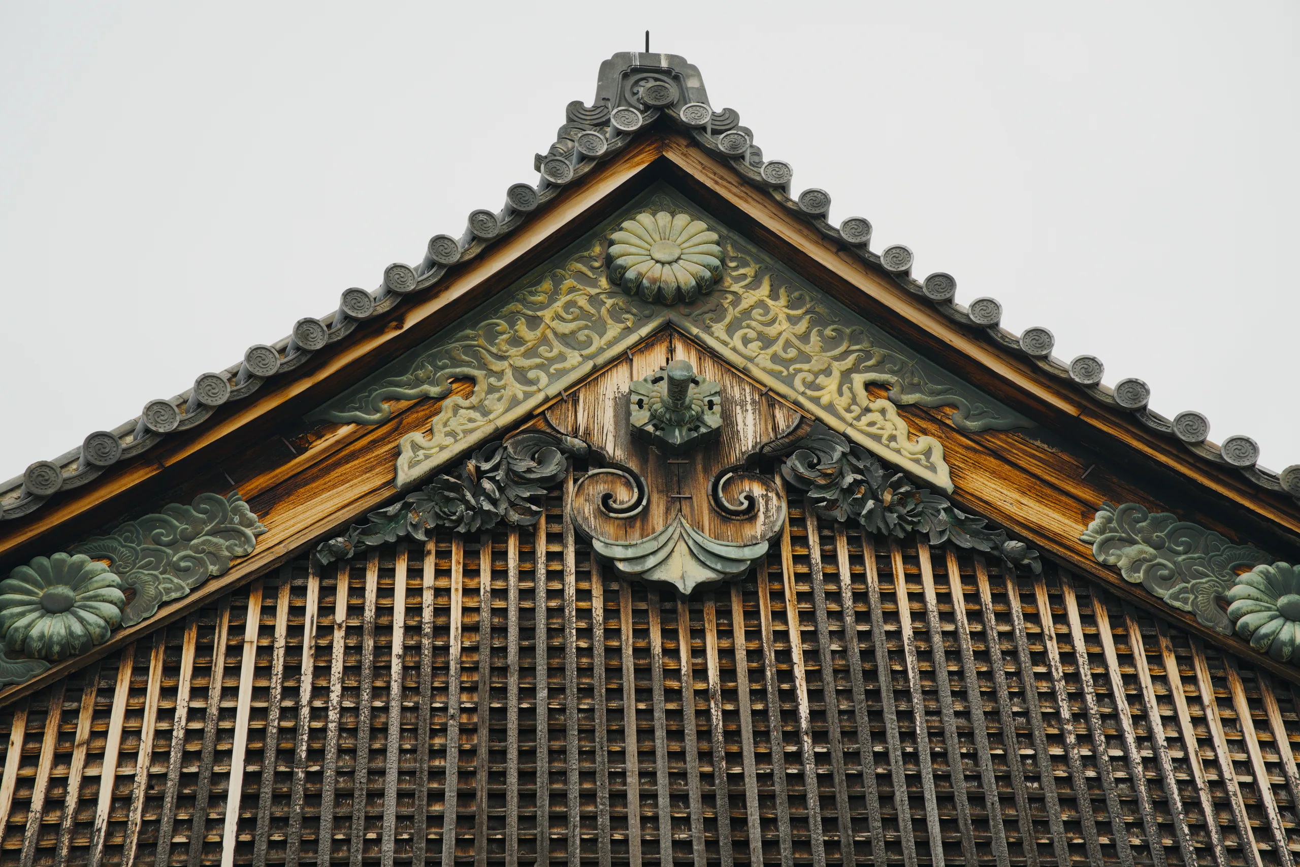 Japanese temple gable with gilded carved ornament and slatted wooden ventilation panel.