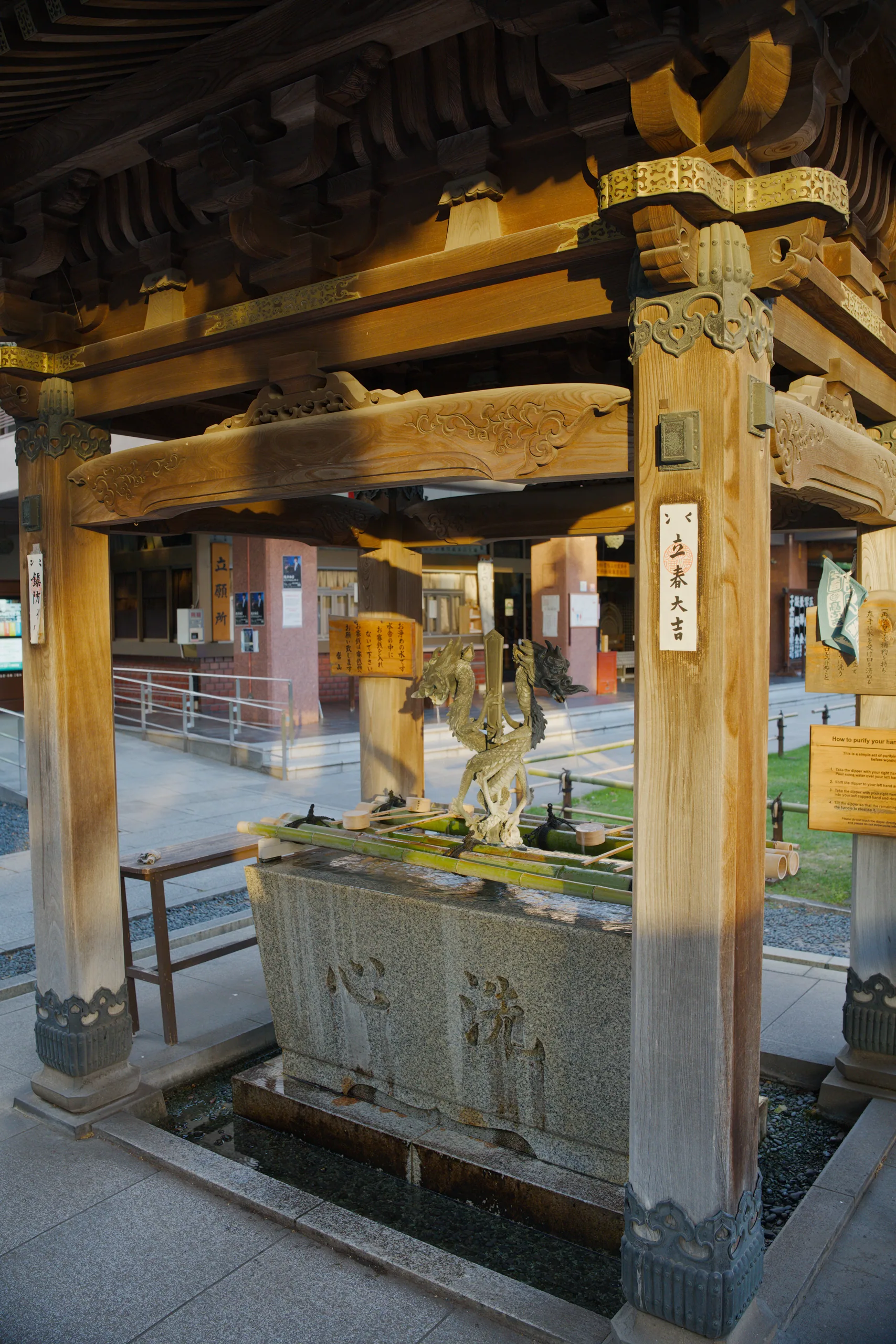A golden shrine gateway with ornate wooden posts and ornamental railings.