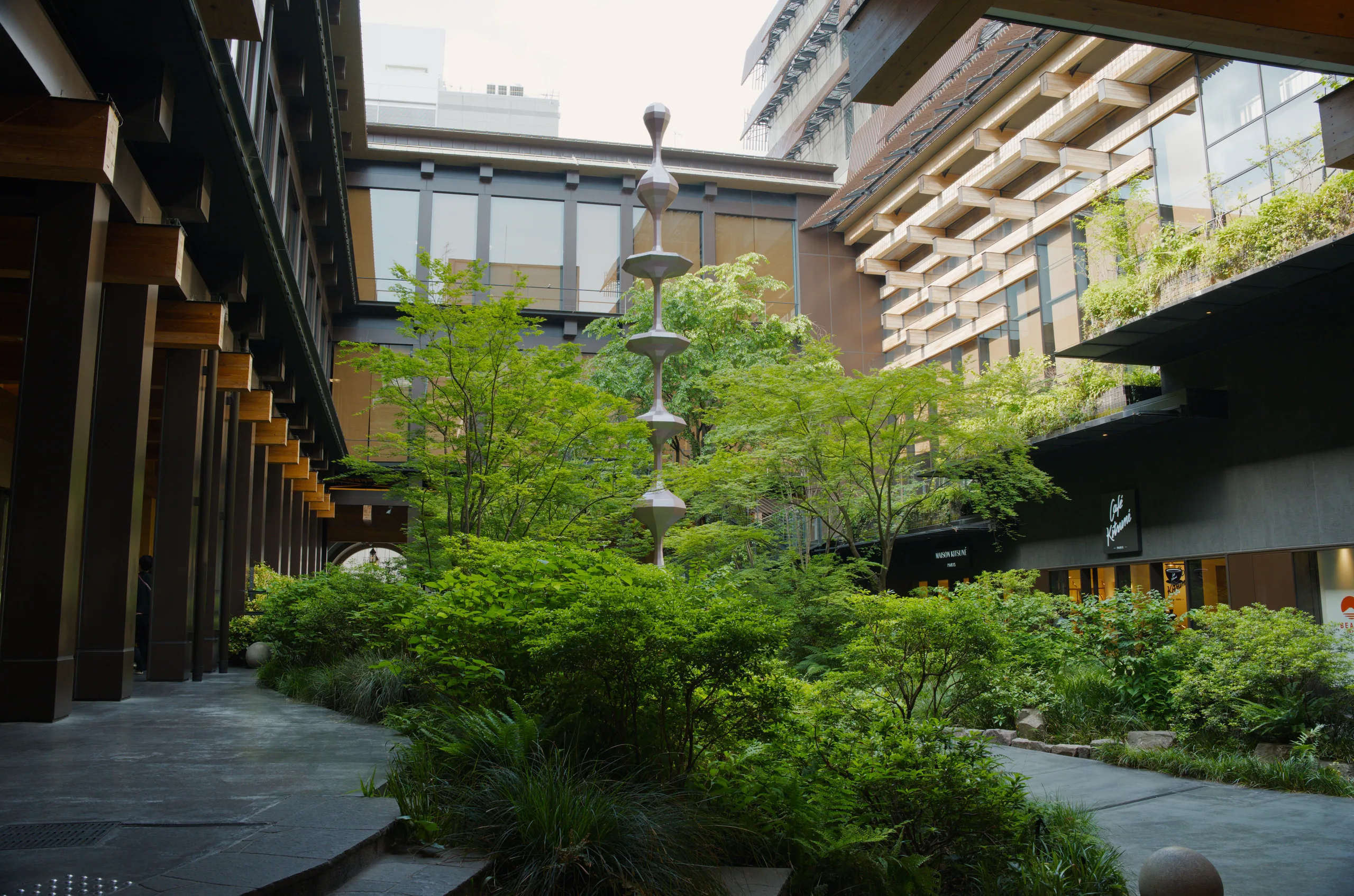 A wooden courtyard with a staircase and climbing ivy covering the building facades.