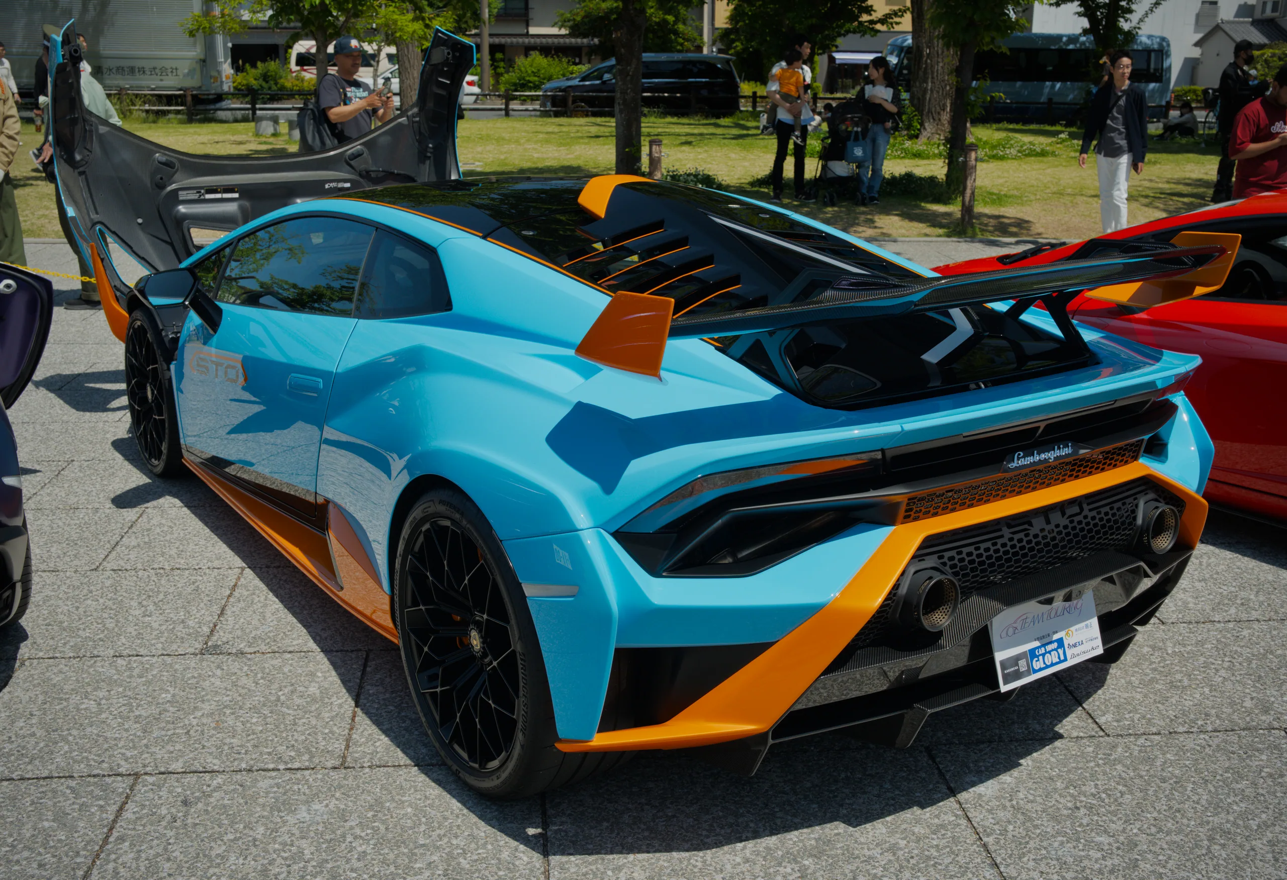 Blue and orange sports cars displayed at a car show.