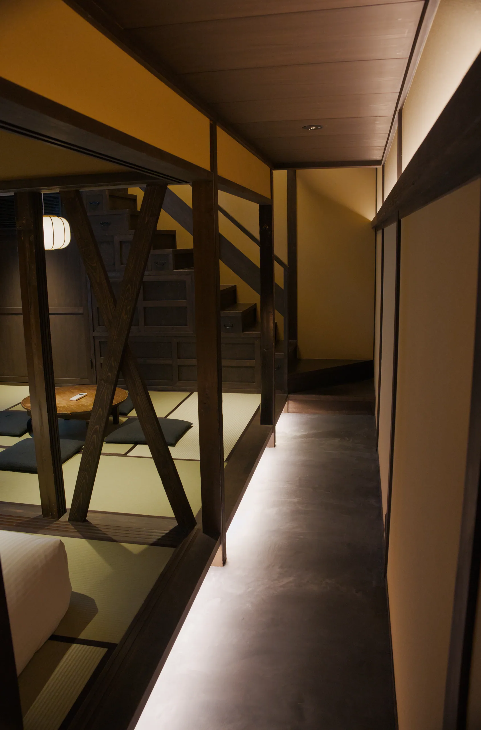 A hallway with wooden ceiling beams and glass partitions in a Japanese interior.