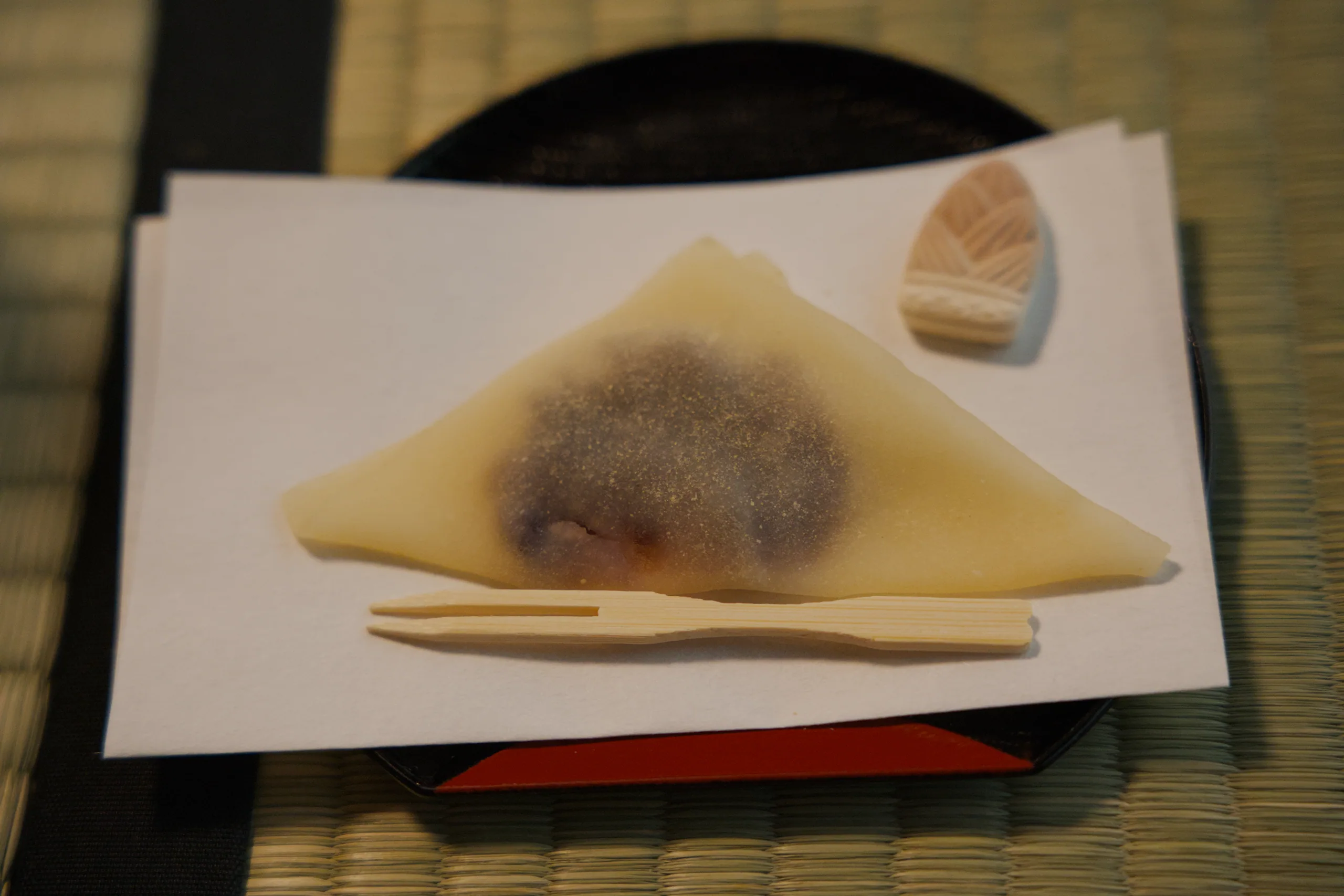 Two triangular tea cakes dusted with powder on a white ceramic surface.