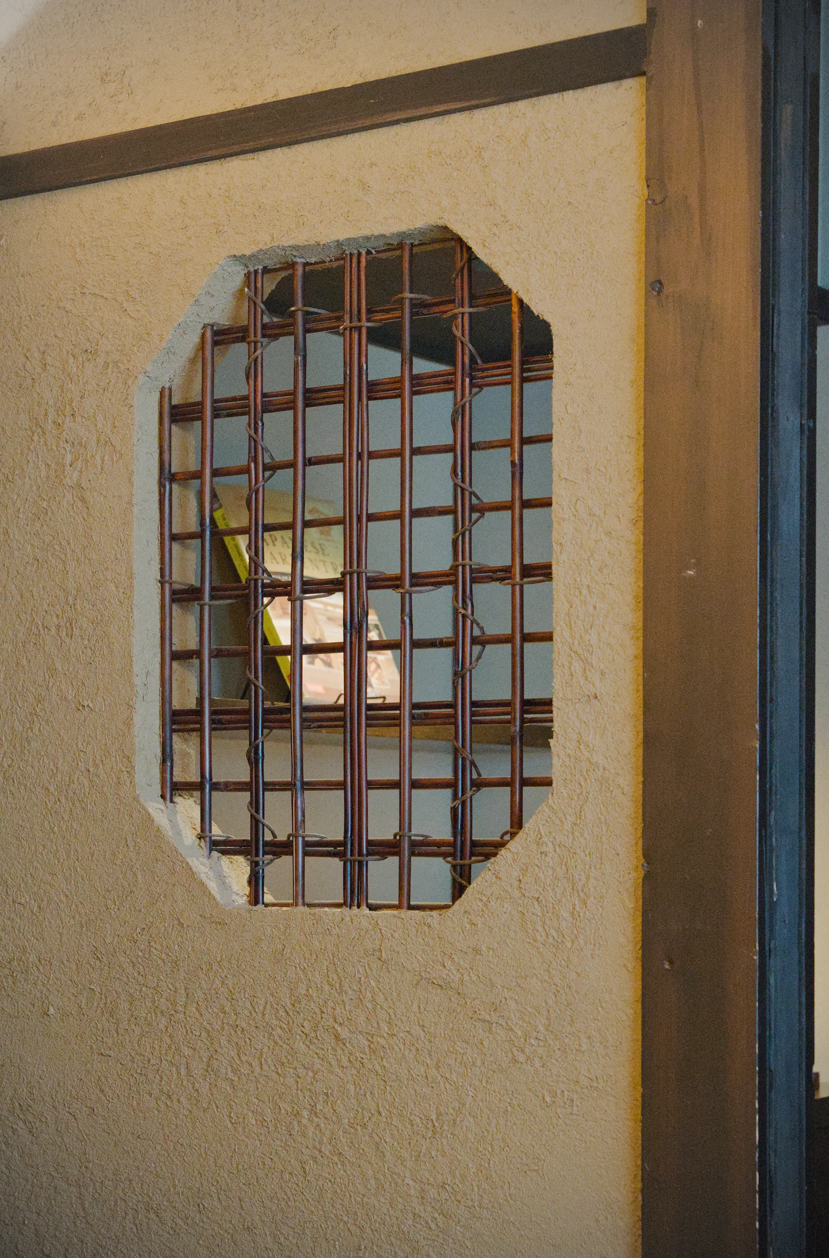 Cream-colored wall with a recessed grid or lattice screening detail.