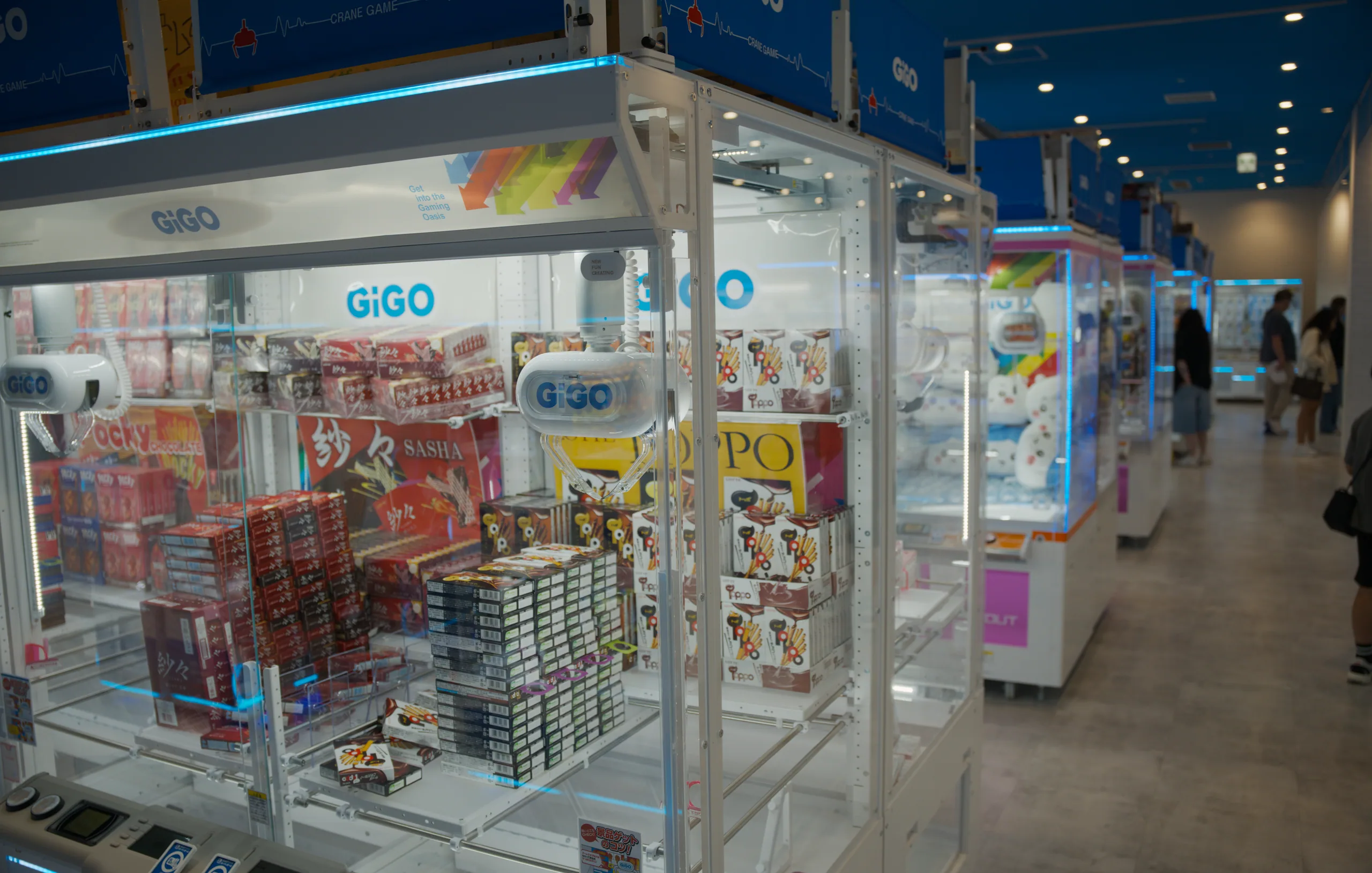 A GIGO storefront with illuminated product displays in an indoor shopping arcade.