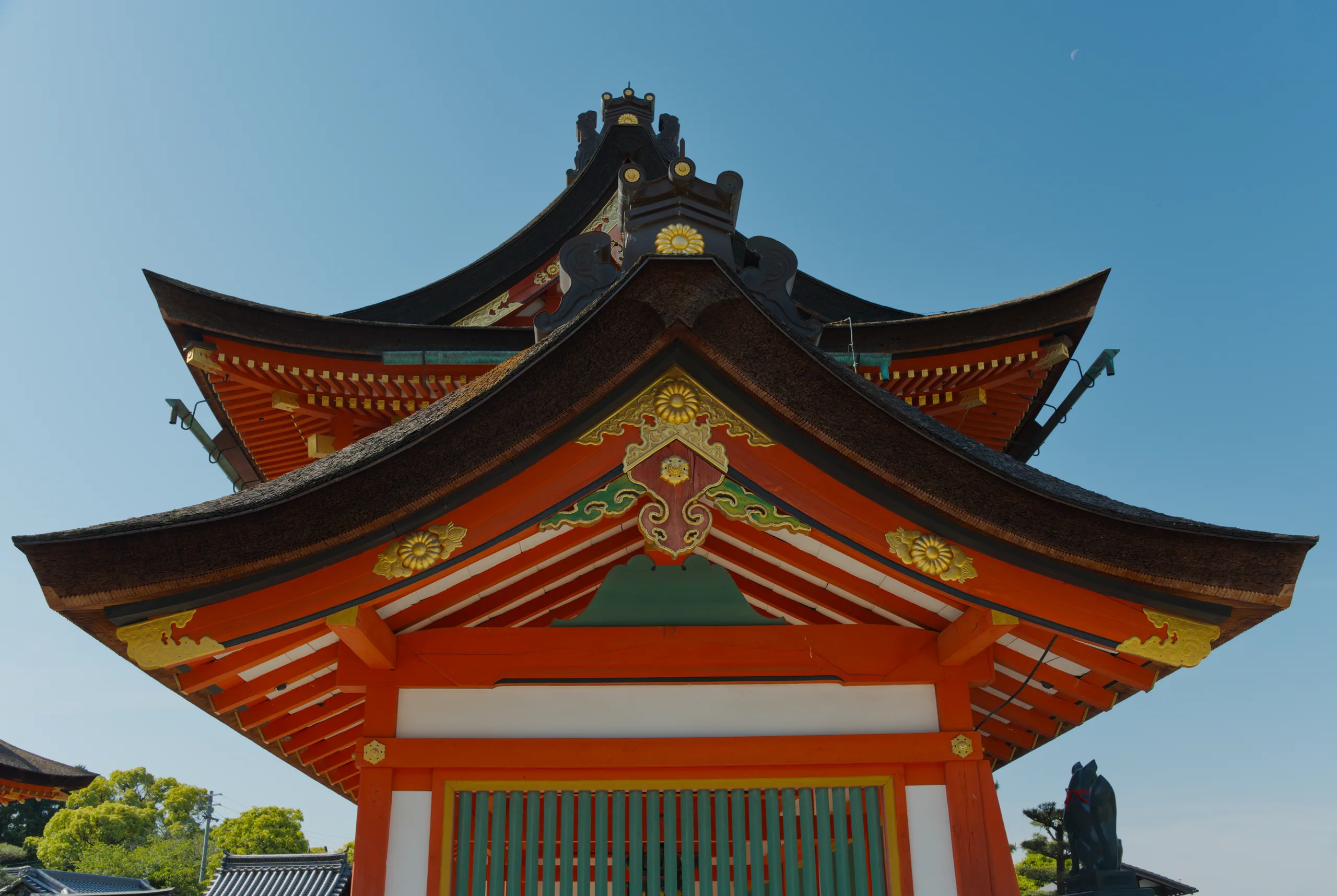 Close-up of a Japanese temple roof with red lacquer and gold ornamental details.