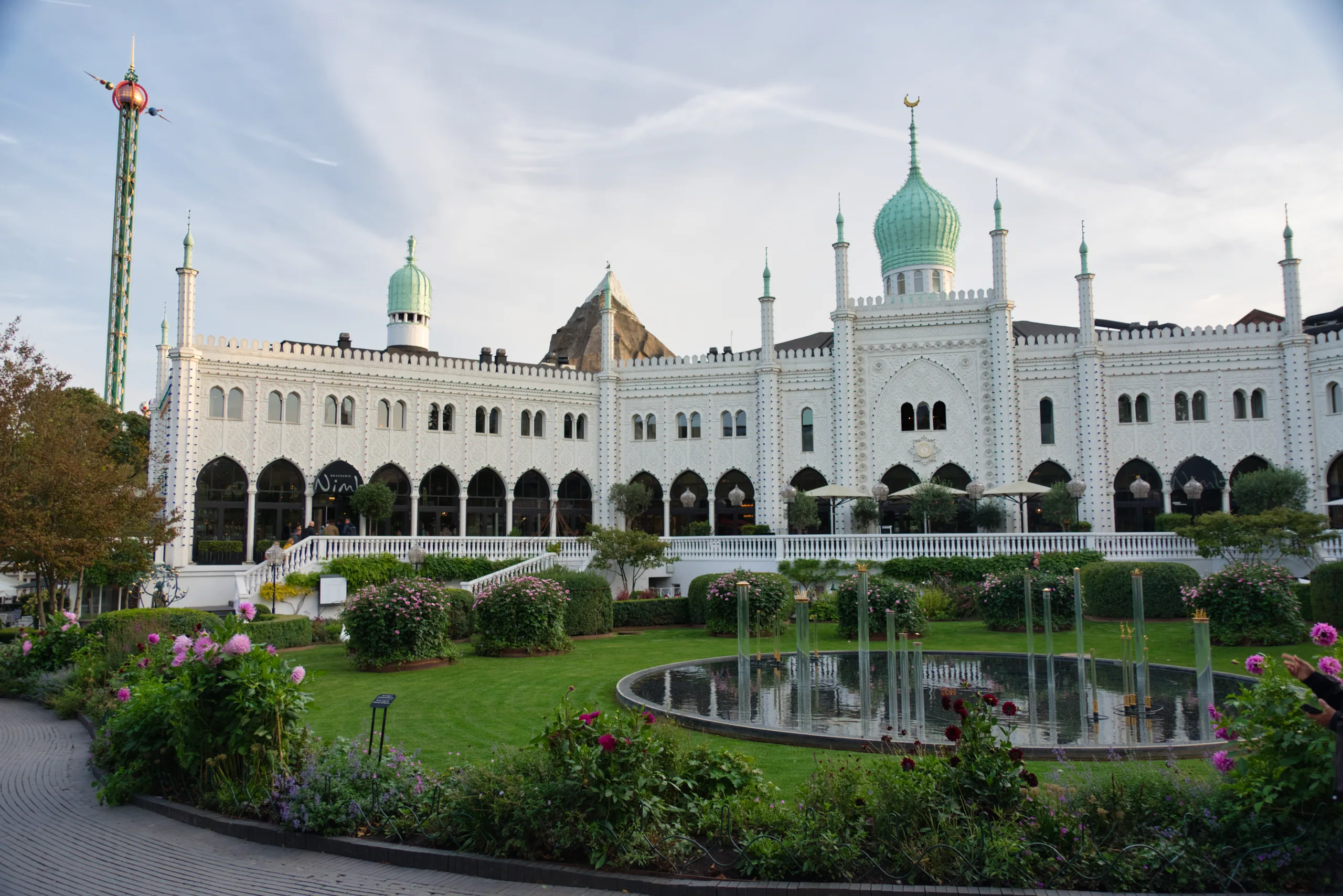 The white Moorish-style pavilion at Tivoli with its green onion domes, seen across a fountain pool and flower beds.
